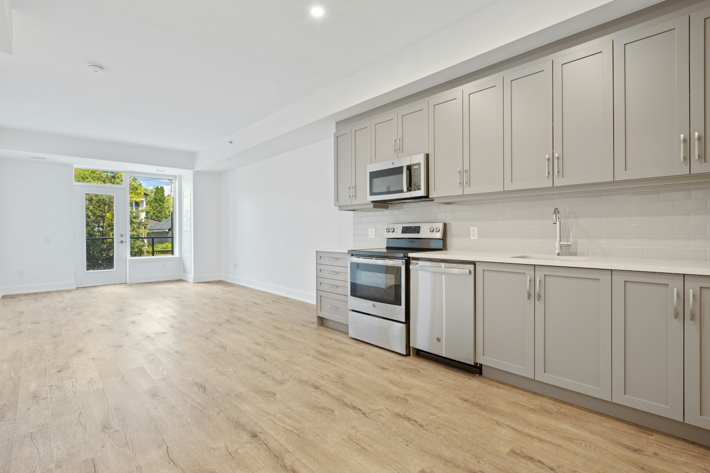 Apartamento moderno sin muebles con cocina y balcón.