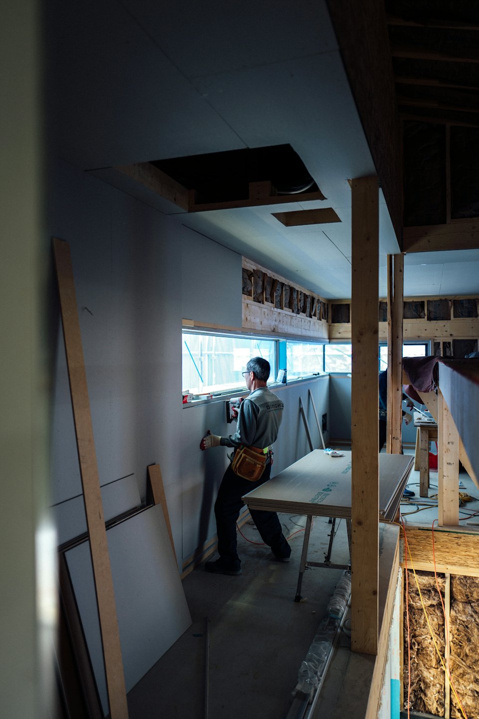 Un trabajador de la construcción instala paneles de yeso en el interior de un edificio.